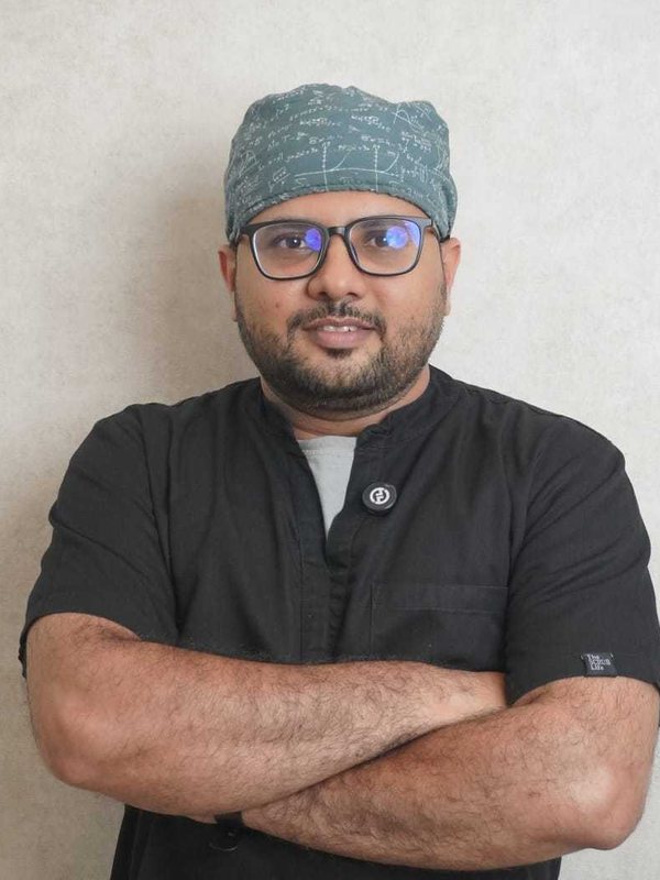 Dr. Irfan Ahamed Shaik in surgical scrubs and cap